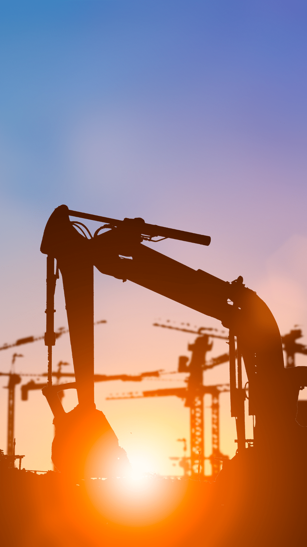 Utility worker with tablet at transmission pylon at dusk